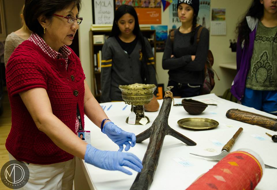 Image depicting volunteer Lani Chan describing how a coconut scraper is used to visiting group from Pittsburgh's YFAP. Selected for use on the homepage of the Philippine Heritage Collections interactive web portal. (c) Field Museum of Natural History - CC BY-NC 4.0