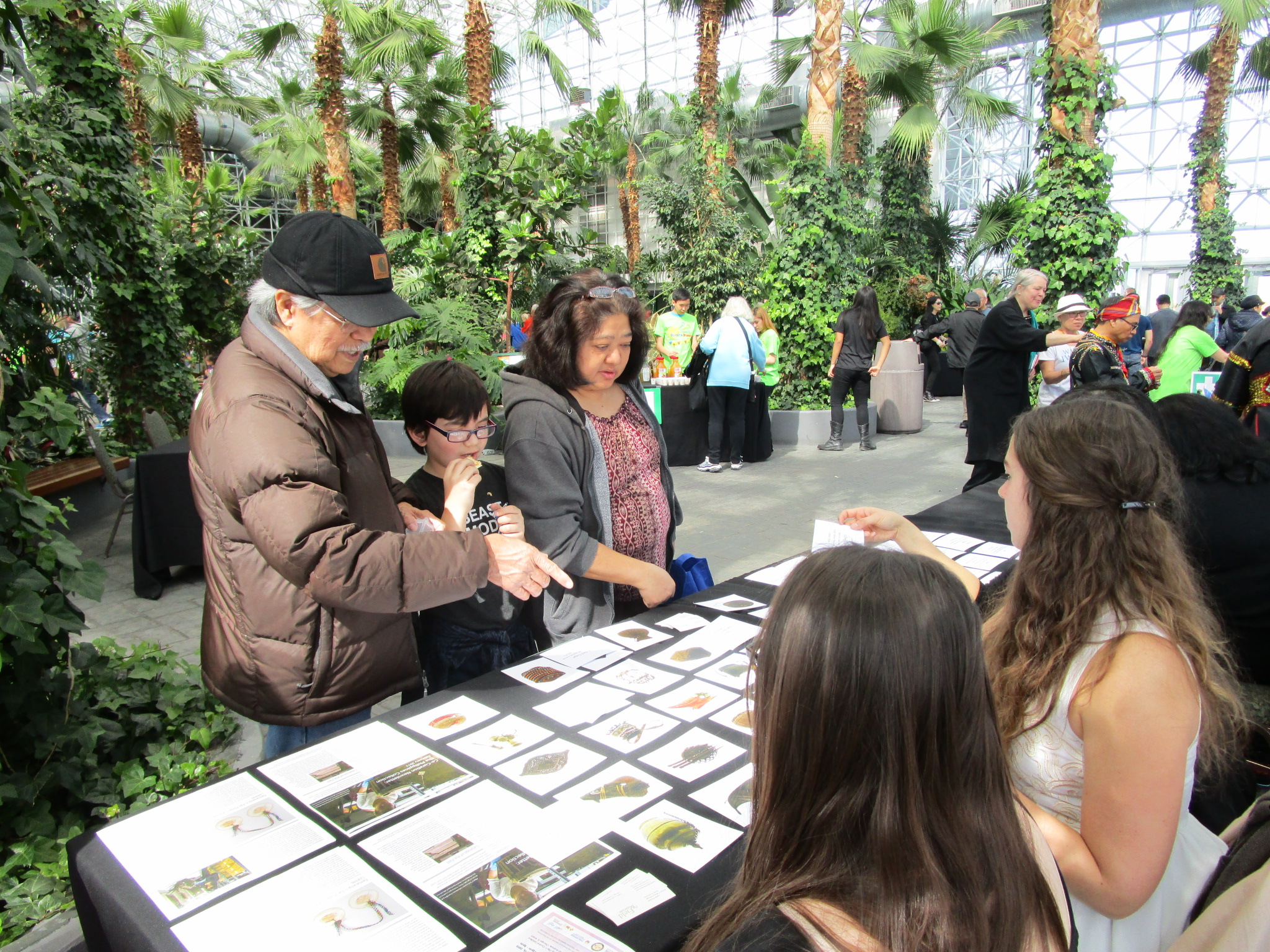 Family playing a guessing game based on artifacts in the collection at The Field Museum's table. (c) Field Museum of Natural History - CC BY-NC 4.0