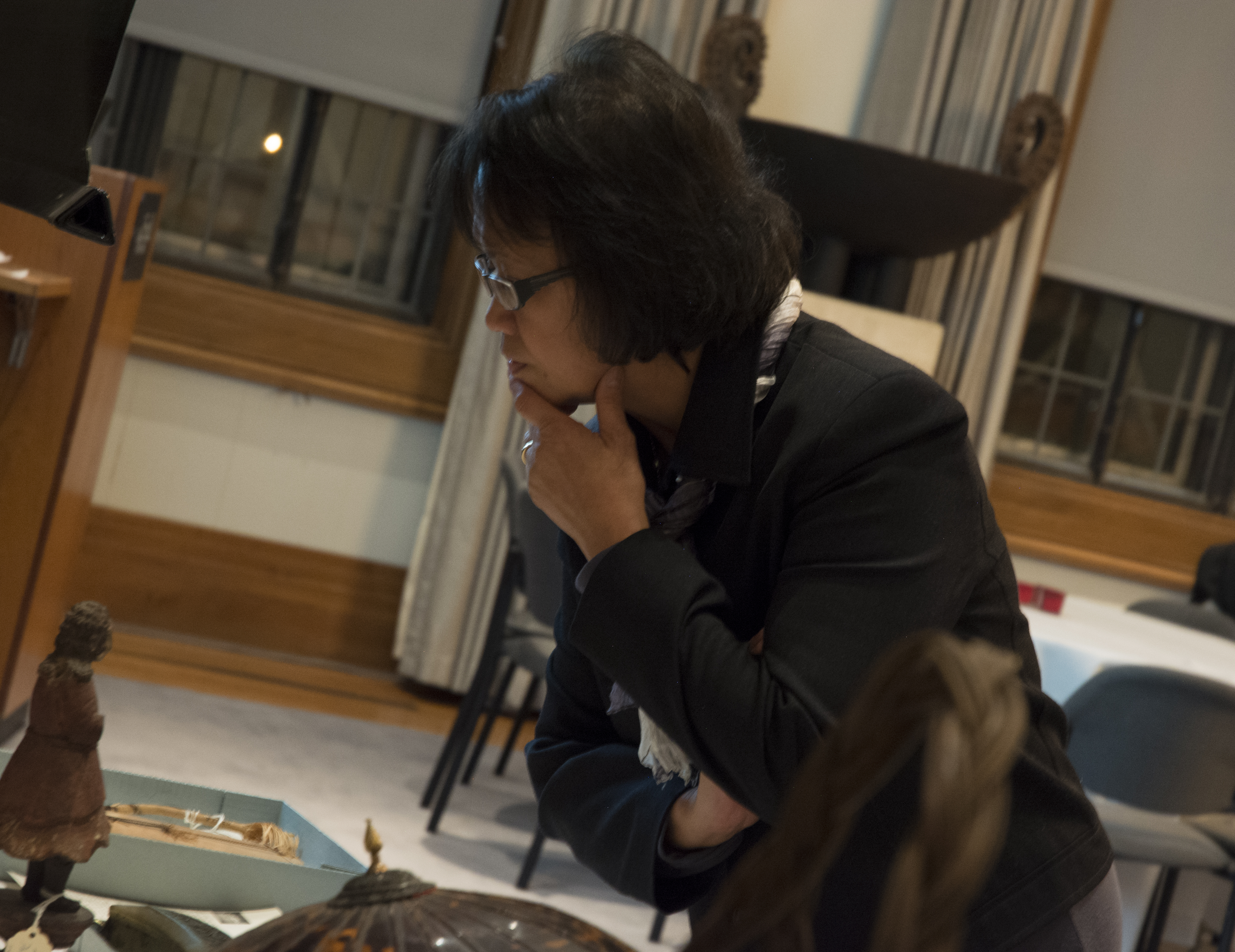 Guest Merle Salazar looks over the artifacts displayed on the tables. (c) Field Museum of Natural History - CC BY-NC 4.0
