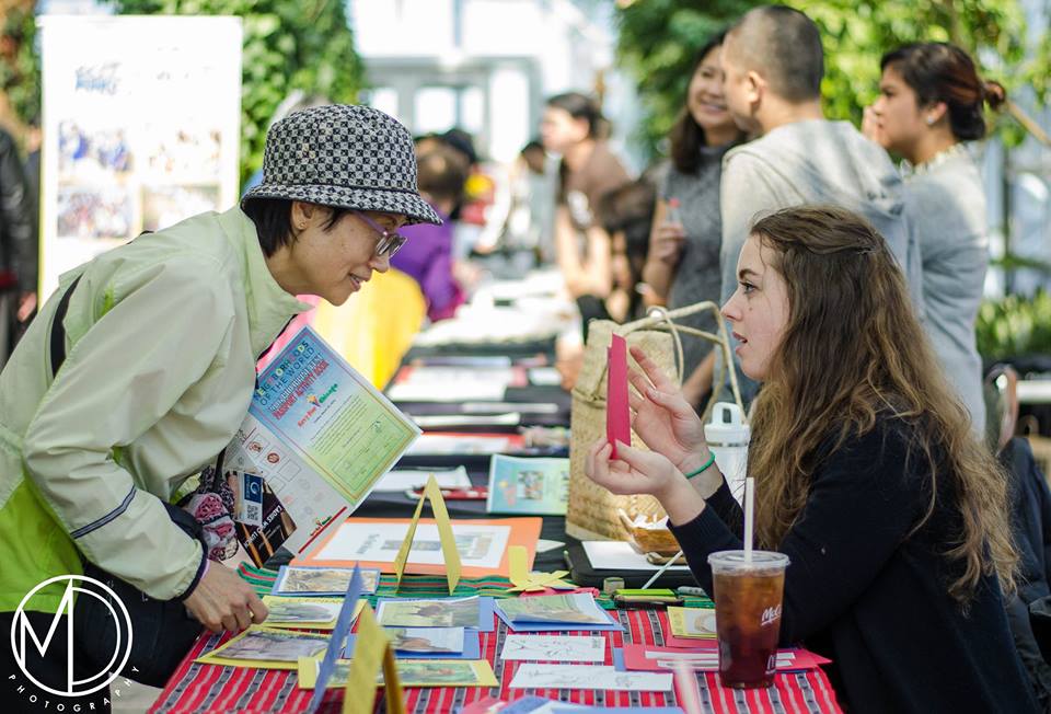 Cassie showing an image of a collections item to a guest at PACF's Piyesta Pinoy (c) Field Museum of Natural History - CC BY-NC 4.0