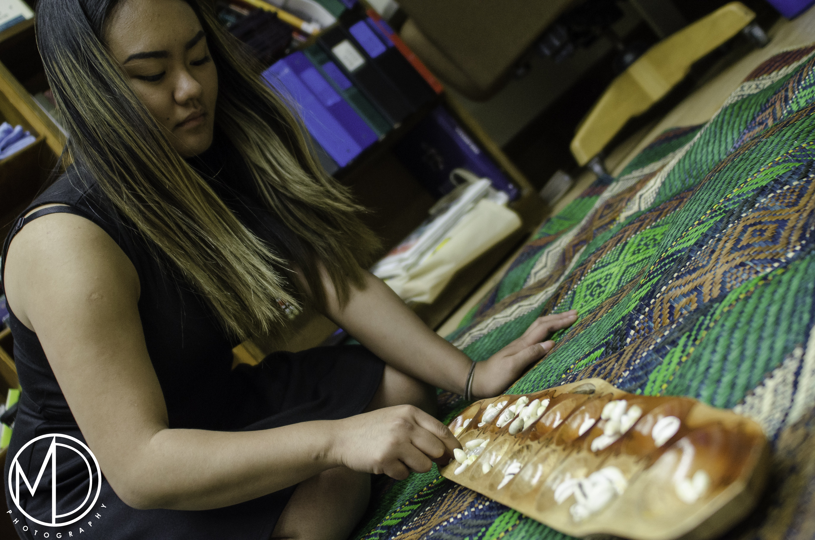 Alpha Sadcopen setting up game of sungca on a non-collections piece for visitors to play. (c) Field Museum of Natural History - CC BY-NC 4.0