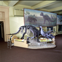 Triceratops model skeleton in Life Over Time exhibit with Charles Knight painting in background