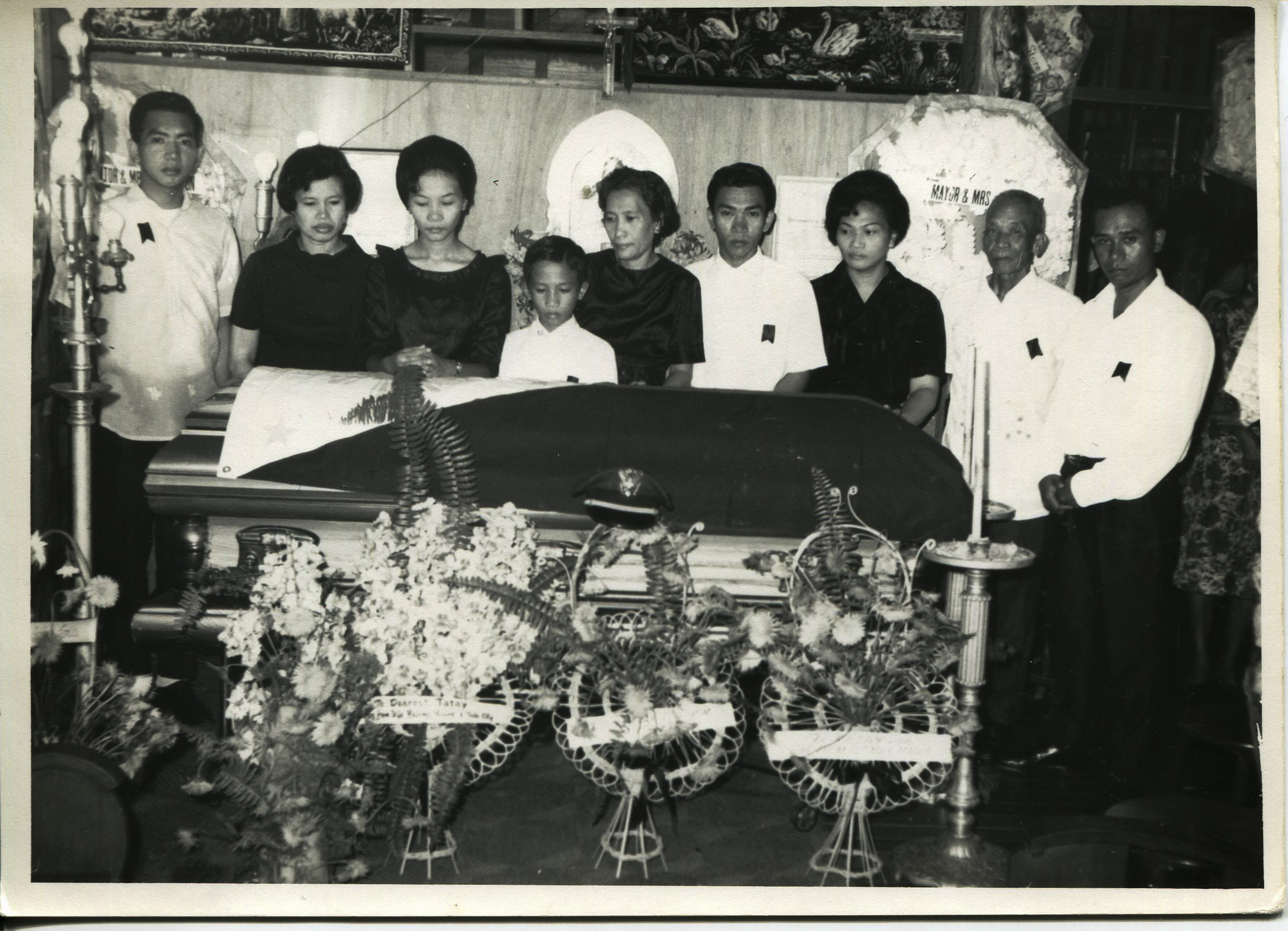 Photo of Arguelles' family, October 13, 1967. Arguelles acquired the photo in 2011 when her dad died. It was taken at Jaro Cathedral in Iloilo City at Arguelles’ grandfather’s funeral. The grandfather was a policeman and his funeral was very impressive with salutes and tributes. Left to right: Pedro (uncle),Magdalena (mother), Isabel (aunt), Eliseo (uncle), “Noning” Dionisia (step grandmother), Ismael (uncle), Amparo (aunt), unknown, father “Toting” Jose. Arguelles likes that this picture shows how important Catholicism has been to her family, and how well loved hergrandfather was. Any views, findings, conclusions, or recommendations expressed in this story do not necessarily represent those of the National Endowment for the Humanities. (c) Field Museum of Natural History - CC BY-NC 4.0