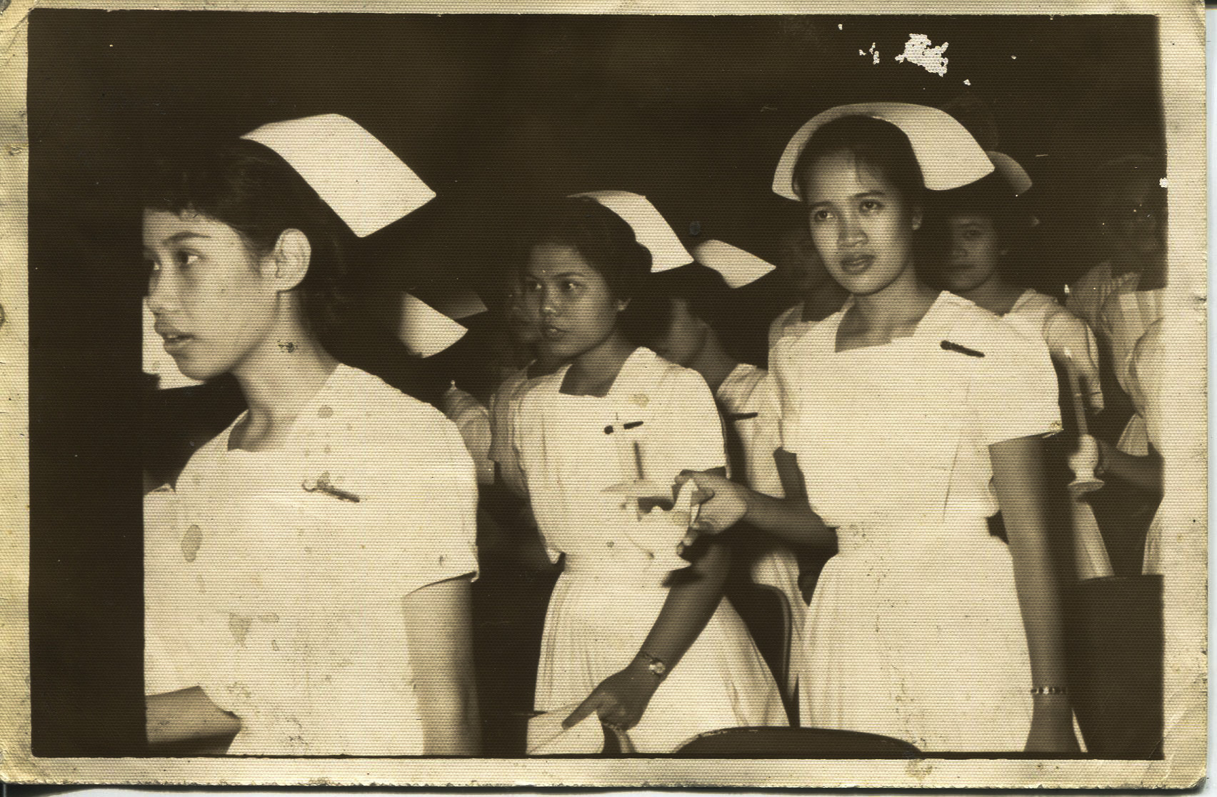 Photo of Tan's graduation, 1963 - frontTaken in 1963 at a graduation from Florence Nightingale at Philippine General Hospital. The back says “Please return to Necitas D. Tan class of 1963”. The photo shows Agnes Bandon (a friend of Tan’s - Bandon is her maiden name); Necitas; and Gaying Dime (a friend ofTan’s). Tan said, “My life started. I was meant to be a nurse”. Tan started school majoring in chemical engineering. Any views, findings, conclusions, or recommendations expressed in this story do not necessarily represent those of the National Endowment for the Humanities. (c) Field Museum of Natural History - CC BY-NC 4.0