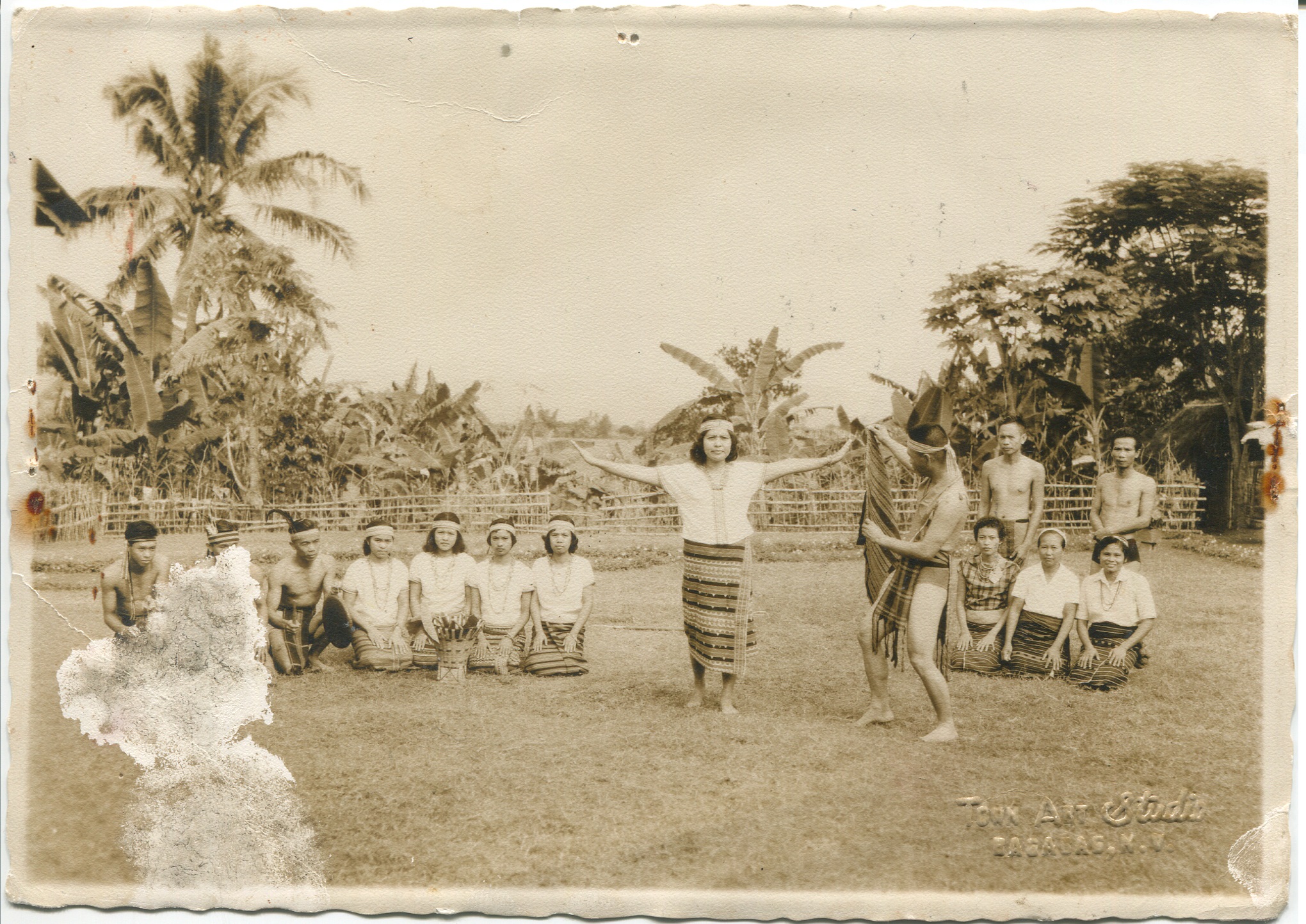 Photo of man and woman dancing, surrounded by other seated dancers. This photograph was taken sometime before 1970 and acquired around 2000 from family, after grandmother passed away. Made in Bagabag, Nueva Vizcaya, Luzon. A woman and man are pictured dancing, surrounded byother people kneeling to watch them dance or take part in the dance. Embossed Text: “Bagabag NV, Town Air Studio”. Reminds Surla of family, grandmother’s pride in her hometown, shows strength and presence. Any views, findings, conclusions, or recommendations expressed in this story do not necessarily represent those of the National Endowment for the Humanities. (c) Field Museum of Natural History - CC BY-NC 4.0