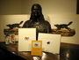 John James Audubon bust held by the Library. An arrangement of books and prints with the sculpture.