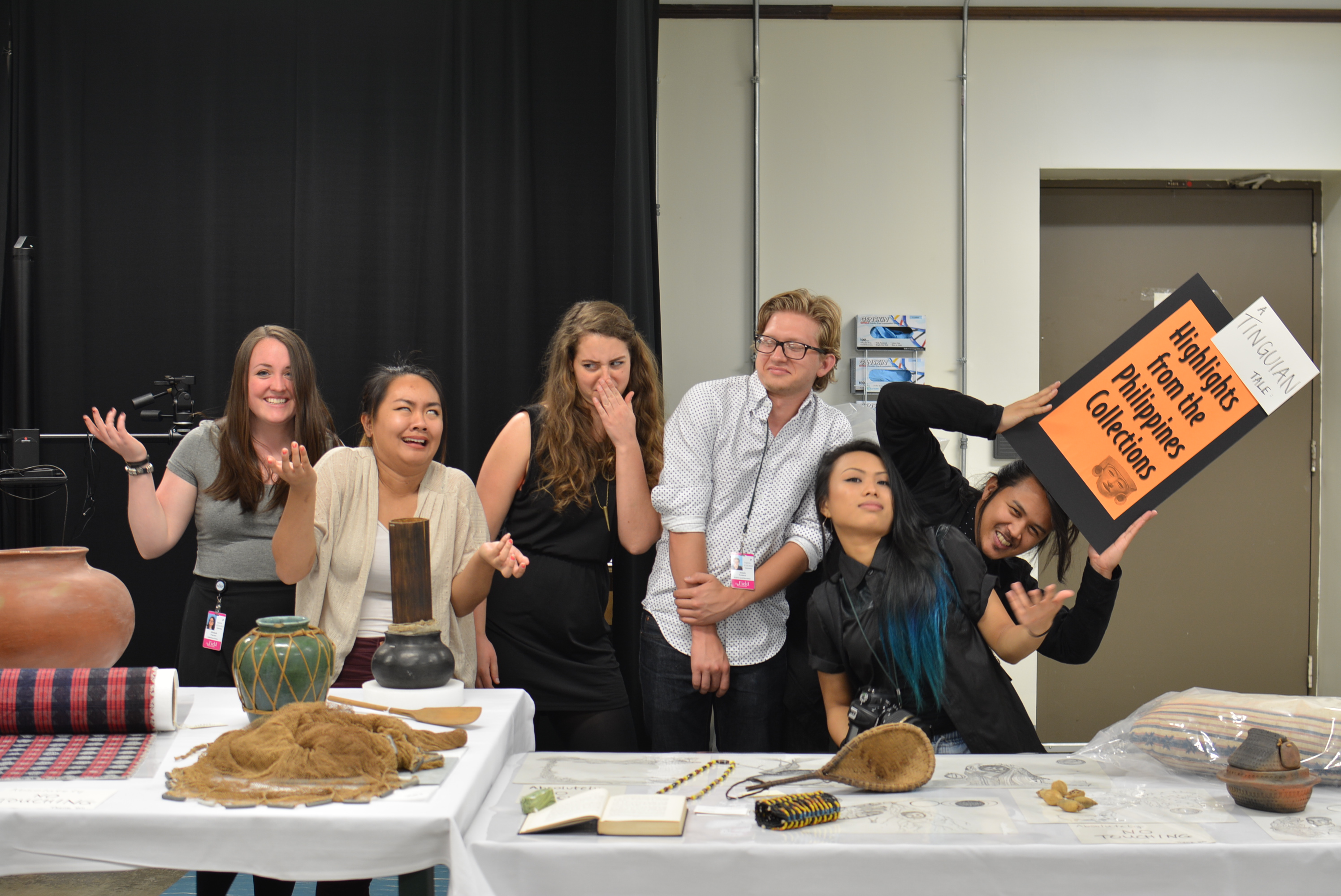 The Digital Co-Curation Team poses for a silly group photo behind their display tables. 