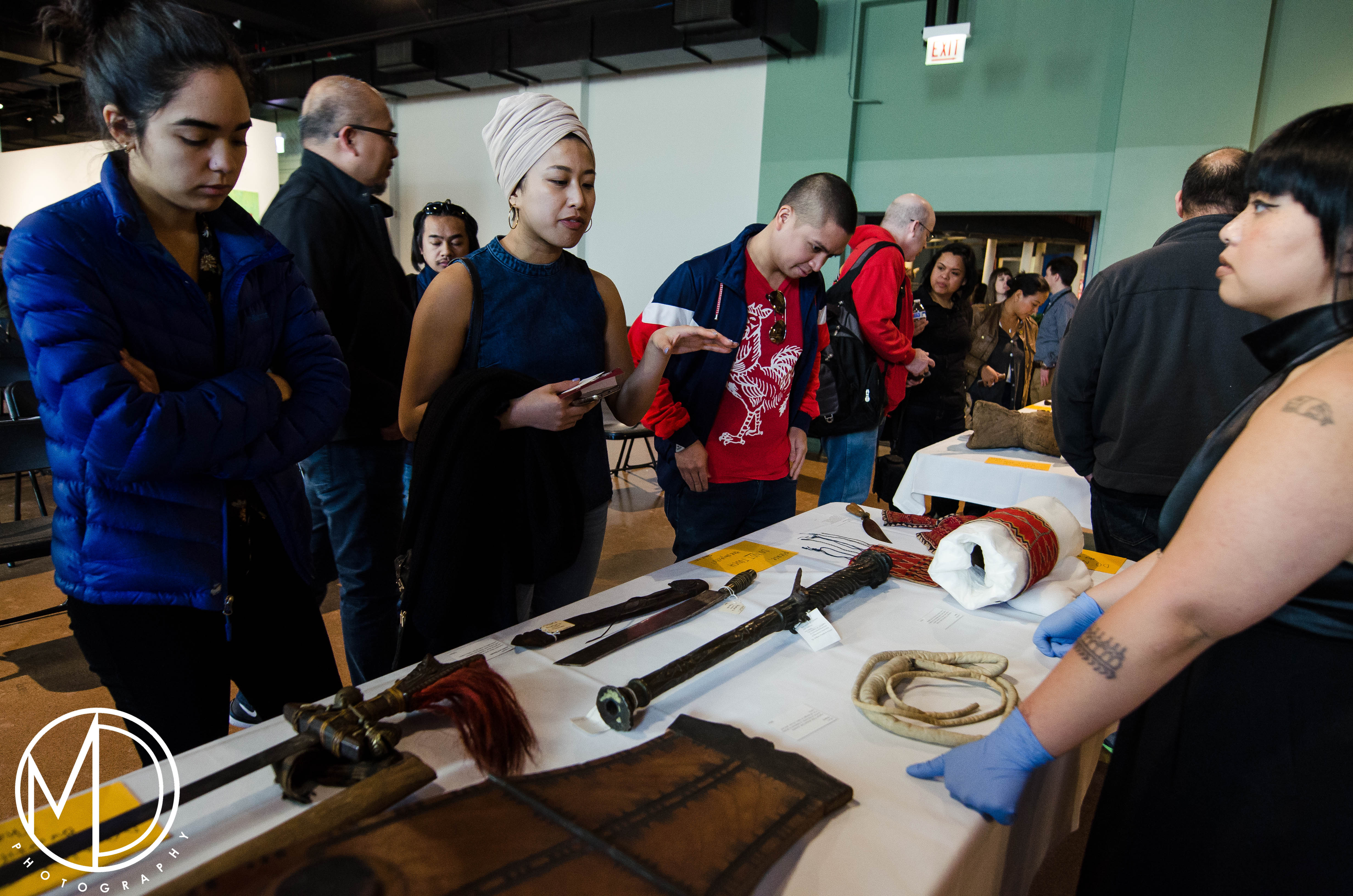 Guests looking at the blades and shields from the collection. 