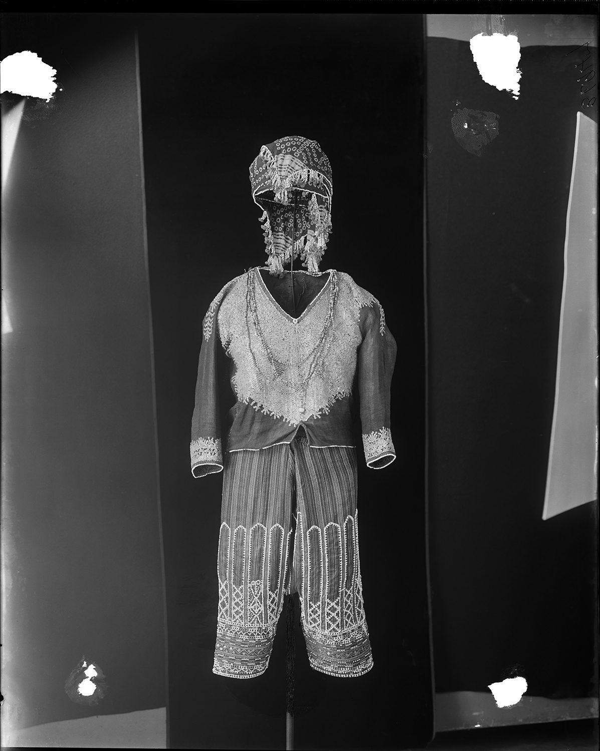 Headband. Bagobo man's suit decorated with beads, shell disks, and appliqué. 